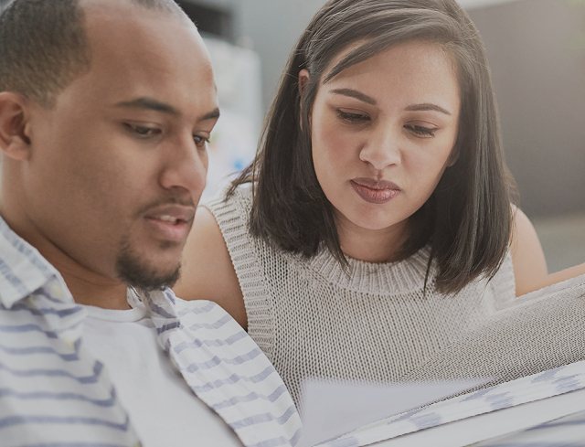 A couple looks over a bill together at home
